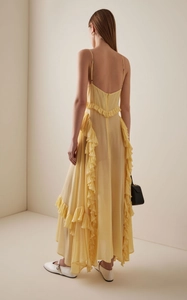 Détail de la robe longue jaune à volants avec fines bretelles et dos nu élégant