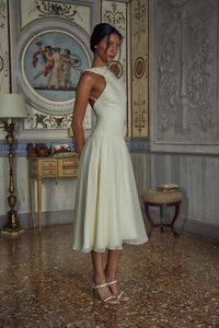 Elegant off-shoulder cream chiffon midi dress with pleated texture in a vintage interior