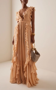 Detail of ruffled apricot evening dress with deep V-neckline and pleated chiffon fabric
