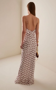 Detail of red polka dot summer dress showing thin straps and ruffled open back design
