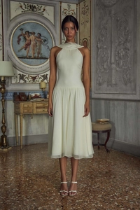 Detail of elegant white pleated halter chiffon evening midi dress in vintage setting
