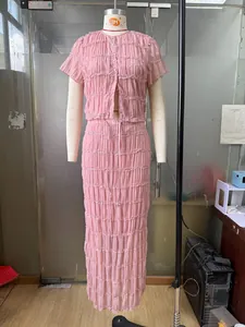 Detail of pink ruffled two-piece set featuring pleated chiffon and sheer textured fabric