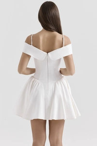 Close-up of the back detail on a white satin cocktail dress featuring a deep backless design