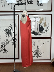 Détail d'une robe maxi sans manches en satin rouge avec une texture lisse et vue de profil