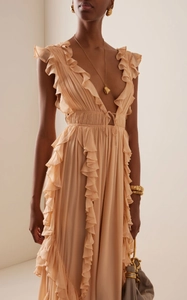 Close-up of pleated apricot chiffon evening gown with V-neck and ruffled edge details