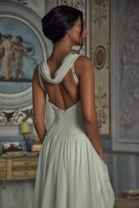 Detailed back view of white chiffon backless evening dress with slim straps and pleats
