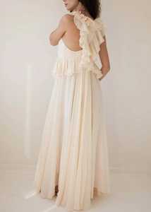 Detail of elegant off-shoulder ruffles and layered chiffon texture on the cream maxi dress
