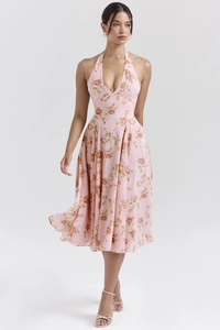 Détail d'une robe fleurie rose à licou col en V avec imprimé rose et jupe évasée d'été
