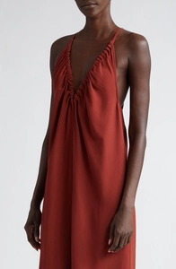 Détail du décolleté en V profond et des plis sur la robe longue rouge brique épurée