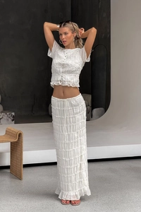 Detail view of white two-piece chiffon set featuring layered ruffles and textured pleats