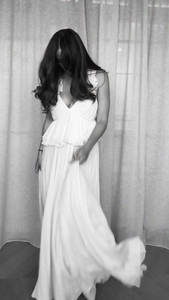 Artistic black and white detail of deep V-neck maxi dress with flowing ruffle edges