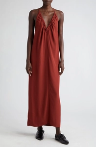 Détail d'une élégante robe longue rouge foncé à plis avec décolleté en V profond