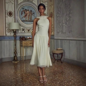 Elegant ivory halter-neck midi dress in pleated chiffon with high-end aesthetic
