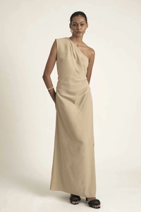 Detail of elegant one-shoulder beige maxi dress with draped waist and pleated fabric
