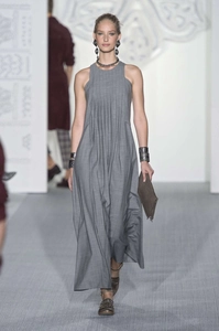 Vue de face d'une robe longue plissée sans manches gris foncé sur le podium de défilé