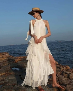 Detailed view of a white halter beach dress with ruffled hem and side split design