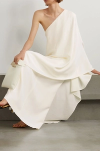 Detail of elegant one-shoulder ivory satin dress with smooth draped texture and pleats
