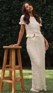 Detail of white two-piece chiffon set showing ruffled edges and tiered pleated texture