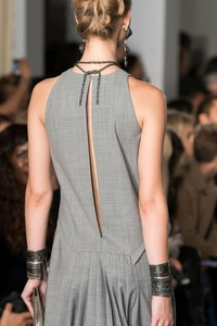 Détail d'une robe grise sans manches avec dos ouvert en V et tissu à texture sergé de luxe