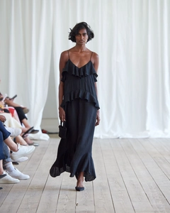 Detail view of a black tiered ruffle maxi dress with spaghetti straps and fluid movement