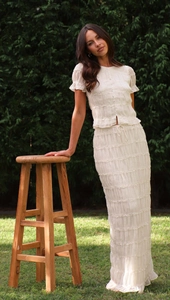 Detail of cream ruffle two-piece set featuring pleated chiffon and pearl buttons