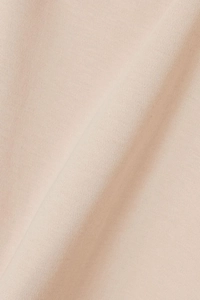 Macro detail of high-quality light beige knit fabric showing smooth texture and soft folds