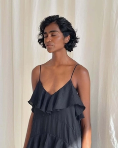 Close-up of elegant black V-neck chiffon dress with ruffled layers and linen texture
