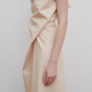 Elegant sleeveless beige maxi dress with asymmetrical neckline and draped linen fabric