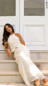 Detail showing ruffled chiffon texture and tiered layering of the cream two-piece set