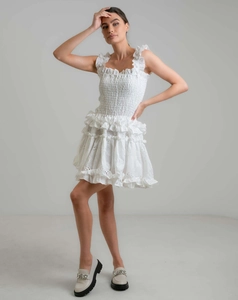 Close-up of white off-shoulder dress with smocking bodice and eyelet embroidery details