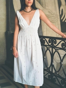 Detailed close-up of white deep V-neck midi dress with intricate eyelet floral embroidery