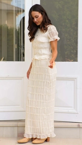 Detailed close-up of cream chiffon set featuring layered ruffles and textured pleats