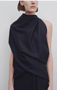 Detail of elegant dark navy sleeveless dress featuring asymmetric draped shoulder design