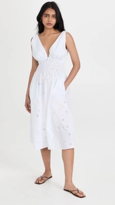Detailed close-up of white V-neck sleeveless dress with delicate floral eyelet embroidery