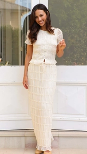Detail of cream chiffon two-piece set featuring ruffled textures and buttoned top