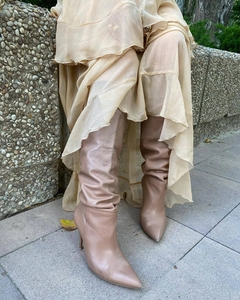 Detailed view of women's beige leather pointed toe stiletto boots with slouchy shaft