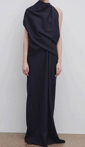 Detail view of the elegant asymmetric neck draping on a sleeveless navy maxi dress