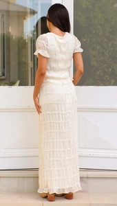 Detail view of the back of a white tiered chiffon maxi dress with ruffled layered design