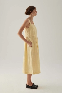 Seitenansicht eines minimalistischen gelben Sommer-Midikleids mit eckigem Ausschnitt