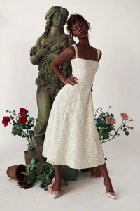 Gros plan détaillé sur la broderie en dentelle blanche de cette élégante robe midi trapèze