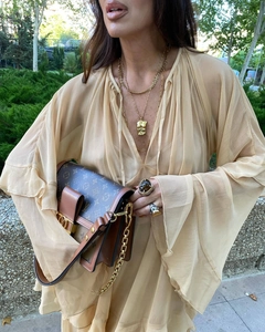 Detail of elegant flare sleeve deep V-neck dress with sheer chiffon and luxury jewelry