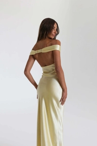 Detail of light yellow satin evening gown featuring an open back and elegant draped design