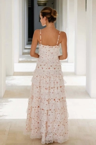 Back view of a tiered white floral maxi dress with delicate lace trim and ruffles