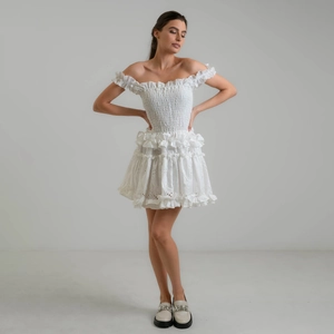 White off-shoulder smocked mini dress with eyelet embroidery and ruffle hem details