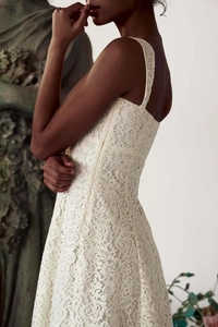 Détails de la dentelle florale ajourée blanc cassé et broderie sur une robe ajustée
