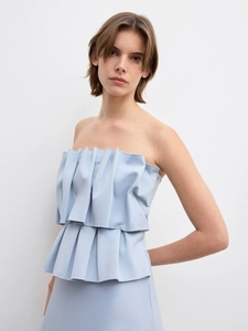 Detailed view of structured ruffles and pleats on a light blue strapless evening gown