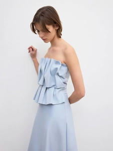 Detail of the light blue strapless dress featuring elegant double-layered ruffled pleats