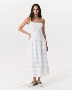 Détail de la robe maxi blanche à carreaux avec fines bretelles et tissu texturé