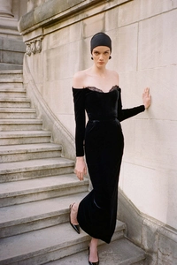 Detail of off-shoulder velvet evening gown featuring elegant lace neckline and long sleeves