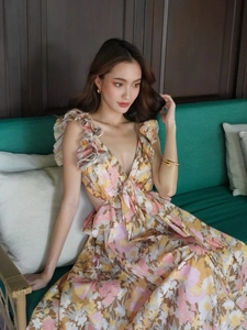 Detail of floral backless dress with deep V-neck, ruffle shoulders and waist cut-outs